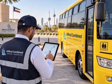An AlRrai Combined supervisor checks a planned route on a tablet beside a yellow school bus.
